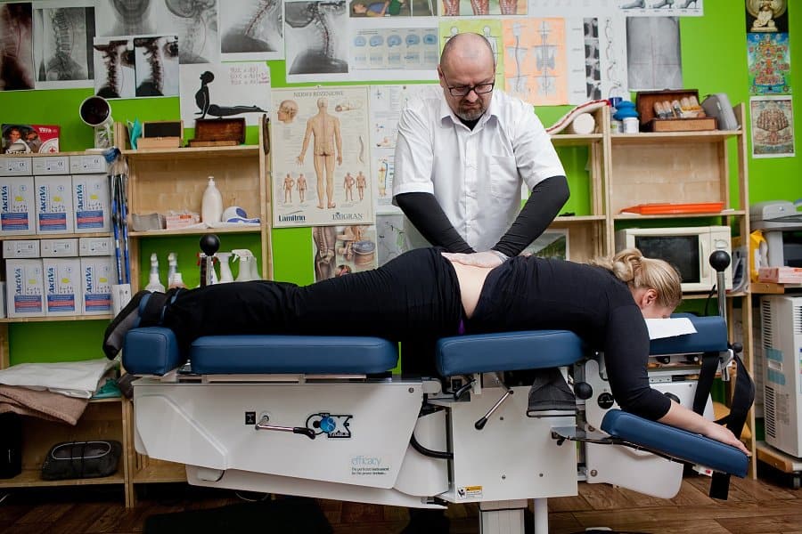 Chiropraktyk w Poznaniu podczas terapii bólu krzyża na stole Cox, Centrum Trzy Diamenty